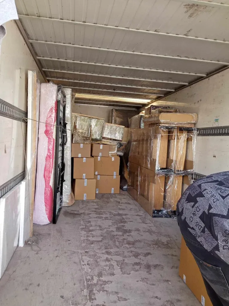 Intérieur d’un camion de déménagement Ben Aissa Transport chargé de cartons et de meubles protégés