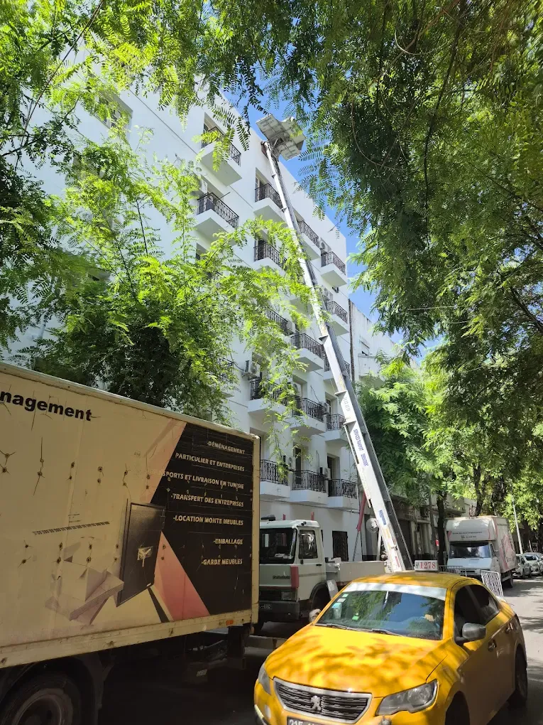 Camion Ben Aissa Transport et monte-meuble déployé devant un immeuble résidentiel à Tunis